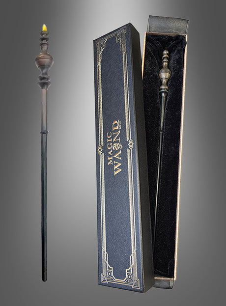 Ein dekorativer schwarzer Zauberstab mit goldener Spitze, der an einen Harry-Potter-Zauberstab erinnert, wird neben einer mit schwarzem Samt ausgekleideten Schachtel mit der Aufschrift „Zauberstab Deluxe in Geschenkschachtel“ präsentiert. Dieser Zauberstab Deluxe ist das perfekte Accessoire für jede angehende Hexe oder jeden angehenden Zauberer, die bzw. der die Zauberschule besucht.
