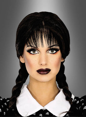Eine Person mit geflochtenen dunklen Haaren, gestylt mit der „Schwarzen Perücke mit Zöpfen für Erwachsene“, dramatischem Make-up und einem Kleid mit Kragen, posiert vor einem grauen Hintergrund mit Farbverlauf.