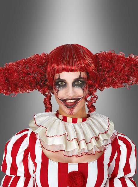 Eine Person in einem rot-weiß gestreiften Kostüm mit Rüschenkragen trägt die „Rote Clown-Perücke Damen“ – eine lockige rote Perücke, die zu verspielten Zöpfen frisiert ist – kombiniert mit auffälligem Clown-Make-up mit übertriebenen schwarzen und roten Akzenten. Der Look wird vor einem grauen Hintergrund mit Farbverlauf in Szene gesetzt und durch das ideale Accessoire für ein unvergessliches Clown-Outfit abgerundet.