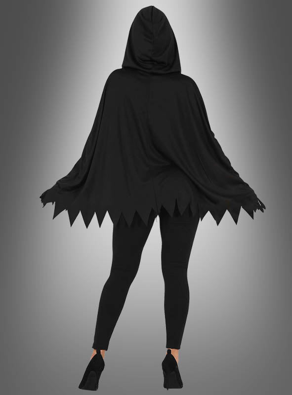 Eine Person, die das „Skelett-Poncho“-Halloween-Kostüm trägt – einen schwarzen Umhang mit Kapuze und gezackten Rändern –, kombiniert mit schwarzen Leggings und schwarzen Pumps, steht vor einem grauen Hintergrund mit Farbverlauf.