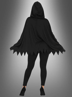 Eine Person, die das „Skelett-Poncho“-Halloween-Kostüm trägt – einen schwarzen Umhang mit Kapuze und gezackten Rändern –, kombiniert mit schwarzen Leggings und schwarzen Pumps, steht vor einem grauen Hintergrund mit Farbverlauf.