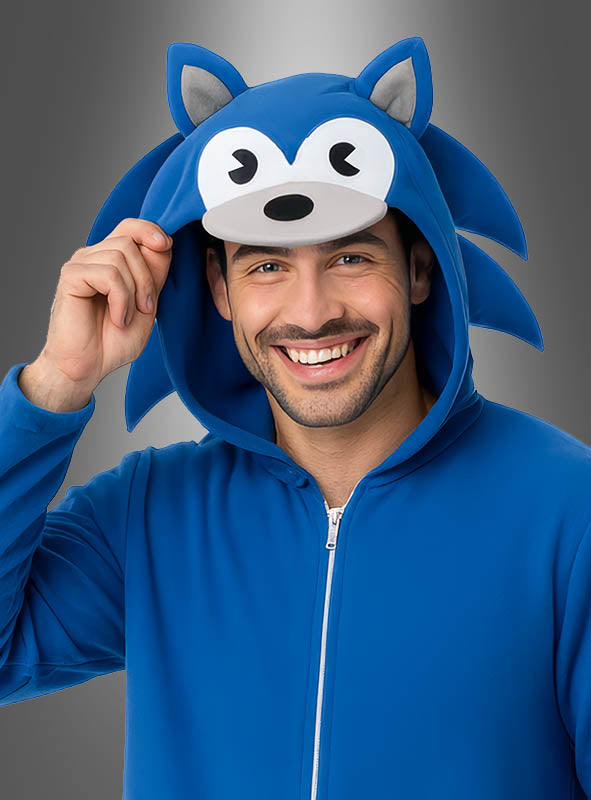 Ein lächelnder Mann trägt den „Blauer Videogame Igel Overall für Erwachsene“ – einen blauen Kapuzenpullover mit Reißverschluss, dessen Kapuze mit von Sonic inspirierten Ohren und Augen verziert ist – und macht ihn so zu einem verspielten Kostüm für Erwachsene, die sich als ihren Lieblingshelden aus Videospielen verkleiden möchten.