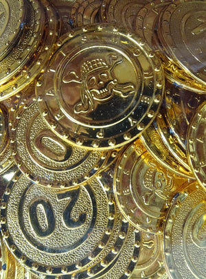 Eine Sammlung goldfarbener „Piraten Geld Goldschatz“-Kunststoffmünzen mit Totenkopfmotiven sowie Münzen, die mit der Zahl 20 gekennzeichnet sind und an Schätze aus einem versteckten Piratenverberg erinnern.