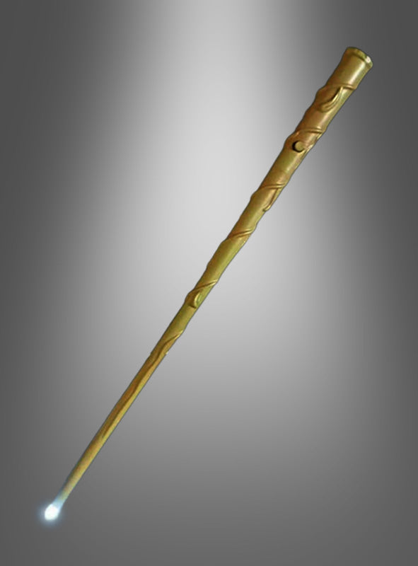 Ein goldfarbener, geschnitzter „Deluxe Zauberin Zauberstab mit LED“ strahlt an seiner Spitze ein kleines weißes Licht vor einem grau verlaufenden Hintergrund aus.