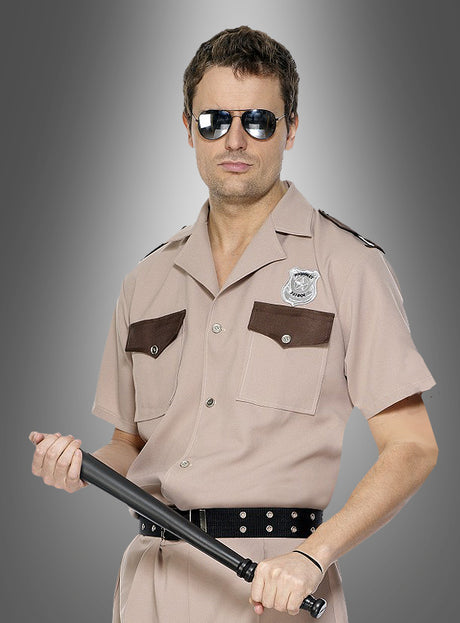 Ein Mann in einer hellbraunen Polizeiuniform und mit Sonnenbrille hält einen 52 cm langen Polizeistock (Schlagstock, Gummiknüppel) in der Hand und steht vor einem grauen Hintergrund mit Farbverlauf.