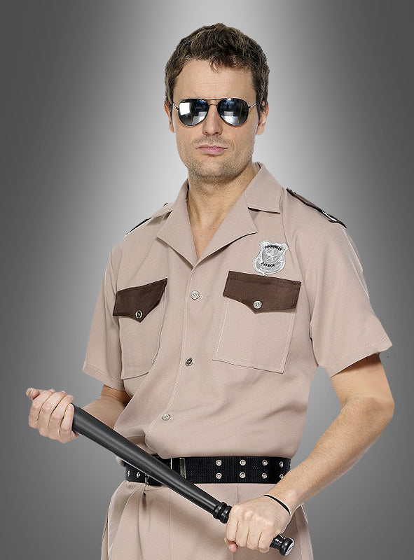 Ein Mann in einer hellbraunen Polizeiuniform und mit Sonnenbrille hält einen 52 cm langen Polizeistock (Schlagstock, Gummiknüppel) in der Hand und steht vor einem grauen Hintergrund mit Farbverlauf.