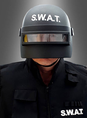 Eine Person, die den SWAT-Helm für Erwachsene in Schwarz trägt, kombiniert mit einer passenden schwarzen S.W.A.T.-Uniform für eine authentische SEK-Verkleidung, steht vor einem schlichten grauen Hintergrund.