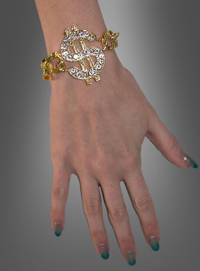 Eine Hand, die das „Pimp Armband mit Dollarzeichen“ trägt, mit einem großen, mit Edelsteinen besetzten Dollarzeichen-Anhänger, vor einem grauen Hintergrund mit Farbverlauf.