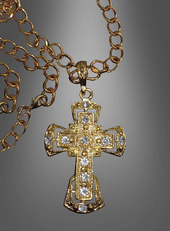 Deluxe-Kreuz-Medaillon mit Kette – ein elegantes Accessoire für festliche Anlässe, inspiriert von der Tradition eines katholischen Geistlichen, präsentiert als goldene Halskette mit aufwendig verziertem Kreuzanhänger und mehreren kleinen, klaren Schmucksteinen vor einem grauen Farbverlaufshintergrund.