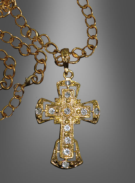 Deluxe-Kreuz-Medaillon mit Kette – ein elegantes Accessoire für festliche Anlässe, inspiriert von der Tradition eines katholischen Geistlichen, präsentiert als goldene Halskette mit aufwendig verziertem Kreuzanhänger und mehreren kleinen, klaren Schmucksteinen vor einem grauen Farbverlaufshintergrund.