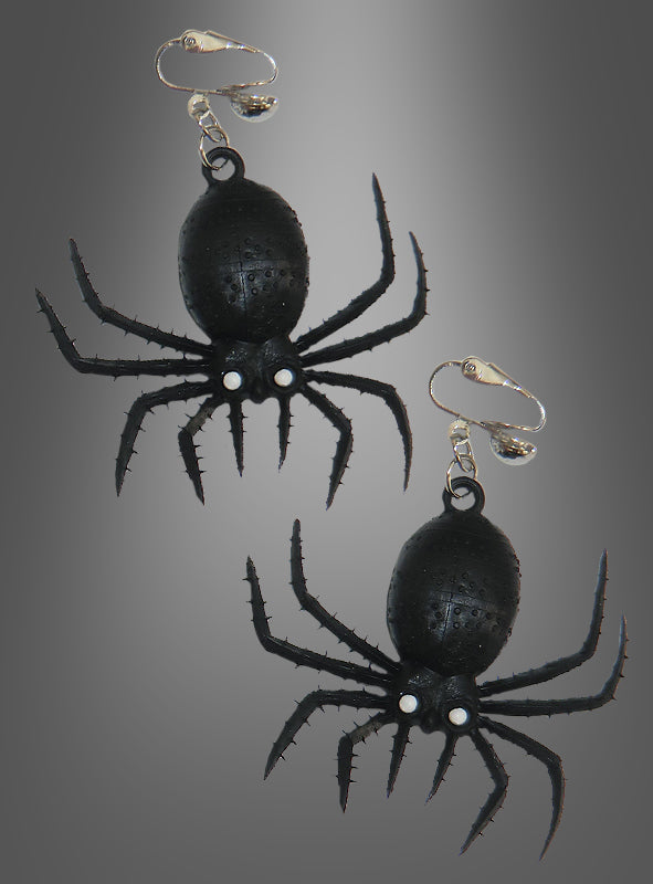 Zwei schwarze Spinnen-Ohrringe – Halloween-Schmuck in Form von Spinnen mit silbernen Clipverschlüssen – werden vor einem grau abgestuften Hintergrund präsentiert – perfekt als gruselige Ohrringe für deine nächste Halloween-Party.
