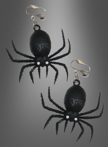 Zwei schwarze Spinnen-Ohrringe – Halloween-Schmuck in Form von Spinnen mit silbernen Clipverschlüssen – werden vor einem grau abgestuften Hintergrund präsentiert – perfekt als gruselige Ohrringe für deine nächste Halloween-Party.