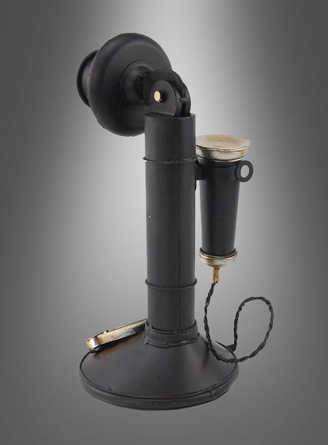 Ein schwarzer Retro-Telefon-Dekokerzenhalter im Stil der 20er Jahre mit drehbarem Sockel, aufrecht stehendem Hörer und fest angebrachtem Ohrstück thront elegant auf einem grauen Hintergrund mit Farbverlauf – ein ideales Stück für eine Vintage-Einrichtung oder jeden retro-inspirierten Raum.