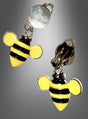 Die „Bienenschmuck“-Ohrclips sind Ohrclips in Form von gelb-schwarzen Bienen mit Metallverschlüssen und einer glänzenden Oberfläche. Diese Ohrringe eignen sich perfekt, um Ihr Bienenkostüm abzurunden oder jedem Outfit eine verspielte Note zu verleihen. Sie werden auf grauem Hintergrund präsentiert.