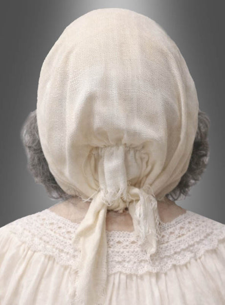 Eine ältere Person mit grauen Haaren, von hinten gesehen, trägt ein cremefarbenes Spitzenkleid und ein leichtes, zusammengebundenes Kopftuch, das an die „Großmutter-Latexmaske mit Haube“ aus einem traditionellen Rotkäppchen-Kostüm erinnert.