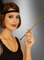 Eine Frau in einem Flapper-Kostüm mit schwarzem Stirnband, kurzem Bob-Haarschnitt und einer Perlenkette hält die „Goldene Zigarettenspitze für 20er-Kostüme“ in der Hand – das perfekte Accessoire für ein Outfit im Stil der 1920er Jahre vor einem grauen Hintergrund mit Farbverlauf.