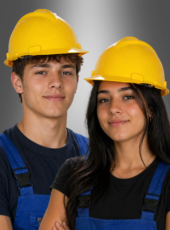 Zwei junge Menschen, die einen verstellbaren Bauarbeiterhelm tragen und gelbe sowie blaue Overalls anhaben, stehen nebeneinander vor einem einfarbigen Hintergrund und blicken in die Kamera.