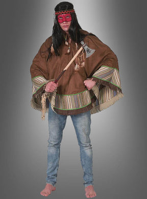Eine Person, die den „Indianer-Poncho für Herren“, blaue Jeans, eine rote Maske und ein Stirnband trägt, hält vor einem grauen Farbverlaufshintergrund einen Tomahawk in der Hand – die perfekte Kleidung für jede „Wilder Westen“-Mottoparty oder als authentisches Indianerkostüm.
