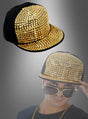 Eine Hip-Hop-Baseballkappe mit goldenen Nieten wird über einer Person präsentiert, die dieselbe Kappe, eine Sonnenbrille und eine Goldkette trägt – vor einem grauen Farbverlaufshintergrund. Ideal für jede 80er-Jahre-Mottoparty oder für alle, die auffällige Accessoires mit goldenen Nieten lieben.
