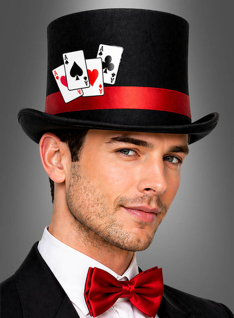 Ein Mann mit einem schwarzen Zylinder im Poker-Casino-Stil, verziert mit einer roten Schleife und drei Spielkarten, dazu ein Smoking und eine rote Fliege vor grauem Hintergrund – das perfekte, vom „Las Vegas Hut“ inspirierte Casino-Kostüm.