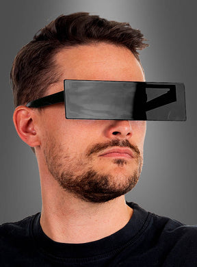 Ein Mann mit kurzen Haaren und Bart trägt eine große, rechteckige „Schwarze Balkenbrille Zensur“. Der Hintergrund ist einfarbig grau.