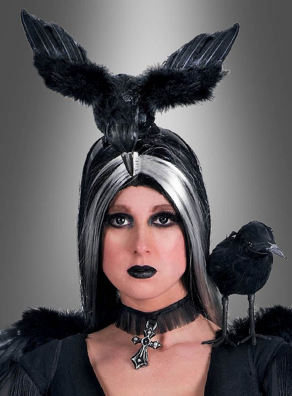 Eine Person mit auffälligem Schwarz-Weiß-Make-up trägt den „Haarreif mit Krähe für Hexen“ als markantes Kopfstück in Form einer Krähe, ergänzt durch eine Krähe als Requisite auf der Schulter und ein Kreuz-Halsband. So entsteht vor einem grauen Hintergrund mit Farbverlauf ein bezaubernder Hexen-Accessoire-Look – perfekt für jedes Halloween-Kostüm.