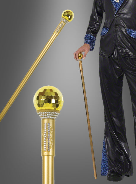 Eine schwarz gekleidete Person hält den „Gehstock 100 cm Macho Pimp gold“ mit einem Griff, der einer Discokugel ähnelt – ein perfektes Kostümaccessoire –, der sowohl in Nahaufnahme als auch in voller Länge zu sehen ist.