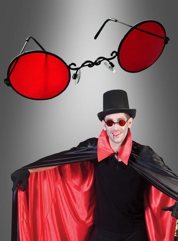 Eine als Vampir verkleidete Person mit einem rot-schwarzen Umhang, einem Zylinder und der auffälligen „Rote Vampir-Brille Nickelbrille“ – oben ist eine Nahaufnahme der roten Brille zu sehen – verkörpert das dramatische Flair des viktorianisch-gotischen Stils.