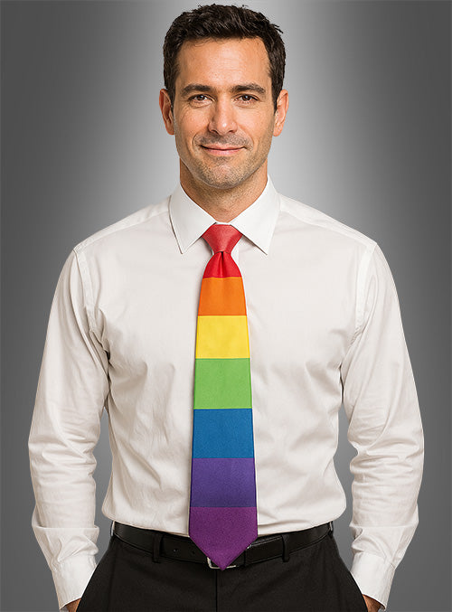 Ein Mann in einem weißen Hemd und einer schwarzen Hose trägt die „Bunte Regenbogen-Krawatte Pride CSD“ und steht vor einem grauen Hintergrund mit Farbverlauf. Er blickt mit einem leichten Lächeln in die Kamera – bereit, auf einem Pride-Festival zu feiern.