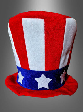 Ein hoher, flauschiger Hut mit roten und weißen Längsstreifen, gekrönt von einem blauen Band mit weißen Sternen – der „USA Stars and Stripes Zylinder aus Stoff“ ist das perfekte Karnevalsaccessoire und ähnelt stark dem legendären Uncle-Sam-Hut.
