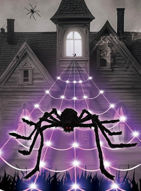 Eine große Spinne mit leuchtend roten Augen sitzt auf dem LED-Spinnennetz (5 Meter mit Spinne) vor einem gruseligen, alten Haus; zusätzliche Spinnen und Spinnennetze schmücken das Gebäude und sorgen so für die perfekte Halloween-Dekoration.