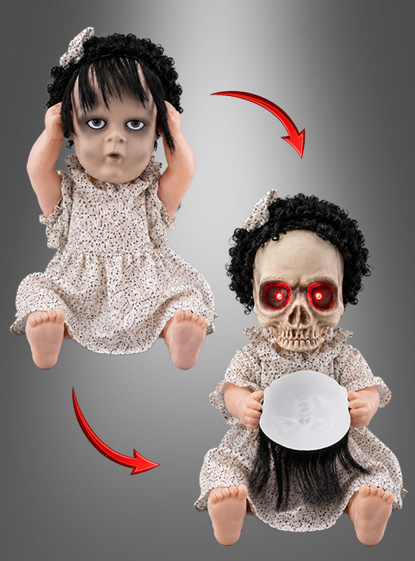 Die 40 cm große animierte Horrorpuppe mit zwei Gesichtern hat dunkles Haar und ein gemustertes Kleid; sie verwandelt sich, indem ihr Gesicht eine Totenkopfmaske mit leuchtend roten Augen enthüllt, während sie ihr abnehmbares Puppengesicht in den Händen hält – perfekt als animierte Horrorpuppe für deine Halloween-Dekoration.