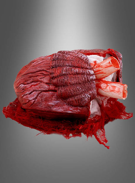 Das „Pochendes Herz mit Licht & Sound“ (21 cm) ist ein äußerst realistisches Modell mit sichtbaren Arterien und Venen, das auf einem grauen Hintergrund mit Farbverlauf präsentiert wird. Dieses animierte Herz dient als auffällige, gruselige Tischdekoration und eignet sich daher perfekt, um Ihren Halloween-Feierlichkeiten eine unheimliche Note zu verleihen.