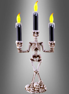 Der „Skelett“-Kerzenleuchter (36 cm) mit LED-Kerzen besteht aus einem Kerzenleuchter in Form eines Skeletts, der drei schwarze LED-Kerzen mit künstlichen Flammen trägt und auf einem Sockel steht, der mit Totenköpfen und einem Grabstein mit der Aufschrift „RIP“ verziert ist – damit ist er der perfekte Halloween-Kerzenhalter, um Ihrer Dekoration einen gruseligen Touch zu verleihen.