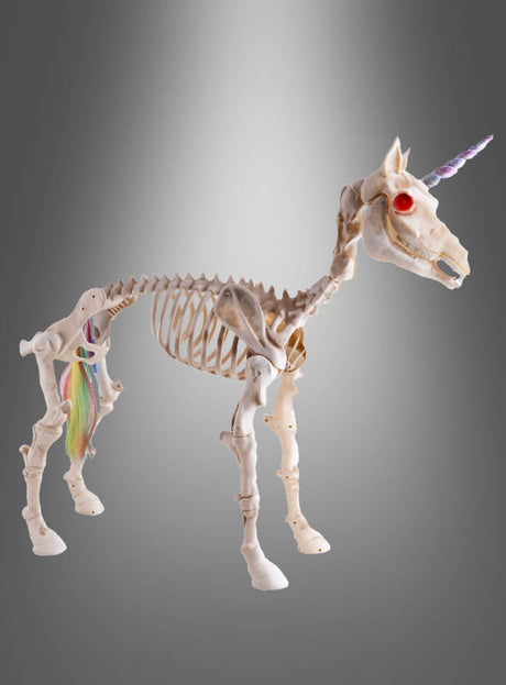 Das „Einhorn-Skelett 60 cm mit Ton und Licht“ mit einem violetten Horn, roten Augen und einem bunten Schwanz wird vor einem grauen Hintergrund mit Farbverlauf präsentiert – und ist damit ein auffälliges Halloween-Dekorationselement oder eine zauberhafte Dekoration für jeden festlichen Anlass.