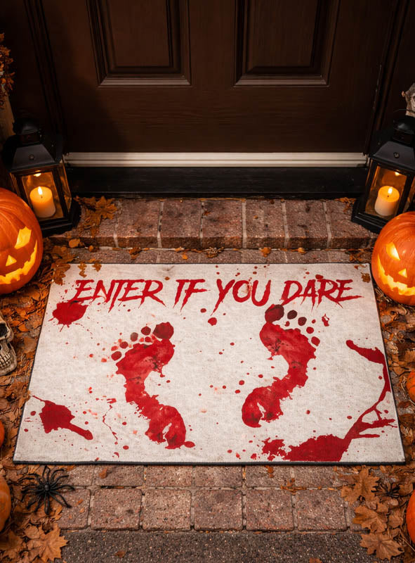 Die „Blutige Fußmatte Halloween“ (60 x 40 cm) mit roten, blutigen Fußspuren und dem gruseligen Spruch „ENTER IF YOU DARE“ liegt vor der Tür, umgeben von Kürbissen, Laternen, Herbstlaub und einer Kunstspinne – die perfekte Halloween-Deko, um deine Gäste mit einer gruseligen Atmosphäre willkommen zu heißen.
