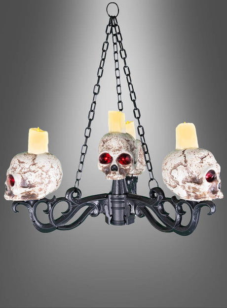 Großer Totenkopf-Kerzenleuchter 155 cm Kronleuchter – ein auffälliger Kronleuchter aus schwarzem Metall mit drei Totenköpfen mit roten Augen und einer verwitterten Optik, die jeweils als Kerzenhalter für gelbe Kerzen dienen. Dieses Stück eignet sich perfekt als Halloween-Kerzenständer und verleiht Ihrem Raum einen gespenstischen Charakter, während der graue Hintergrund mit Farbverlauf seine unheimliche Ausstrahlung noch weiter unterstreicht.