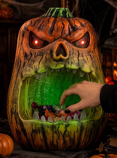Eine Hand greift in den Mund des „Beißenden Kürbisses“ (33 cm), eines großen, leuchtenden Halloween-Kürbisses mit roten Augen und Süßigkeiten aus Plastik im Inneren – damit ist diese animierte Deko der perfekte gruselige Süßigkeitenbehälter für deine festlichen Leckereien.