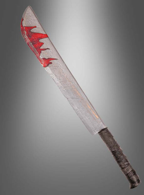 Eine große, silberne „Riesige blutige Machete Halloween 74 cm“ mit einem umwickelten schwarzen Griff und roten Farbflecken auf der Klinge, die an Blut erinnern, fotografiert vor einem grauen Hintergrund mit Farbverlauf – eine ideale Mordwaffe und ein auffälliges Accessoire für jedes Halloween-Kostüm.