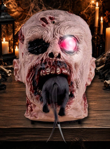 Der 25 cm große, animierte „Rattenfressende Zombie-Kopf“ mit seinem leuchtend rosa Auge und einer Ratte, die aus seinem Mund kriecht, steht auf einem Holztisch, umgeben von Kerzen und Halloween-Dekoration. Diese gruselige Zombie-Dekoration sorgt für die perfekte, schaurige Atmosphäre bei Ihrer gespenstischen Feier.