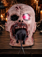 Der 25 cm große, animierte „Rattenfressende Zombie-Kopf“ mit seinem leuchtend rosa Auge und einer Ratte, die aus seinem Mund kriecht, steht auf einem Holztisch, umgeben von Kerzen und Halloween-Dekoration. Diese gruselige Zombie-Dekoration sorgt für die perfekte, schaurige Atmosphäre bei Ihrer gespenstischen Feier.