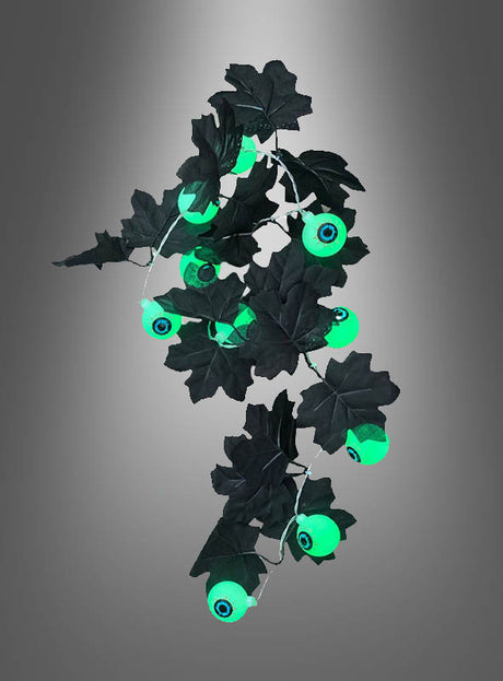 Verleihen Sie Ihrer Halloween-Dekoration das gewisse Etwas mit der Lichterkette „Augäpfel 90 cm Halloween“ – einer Kette aus grün leuchtenden Augäpfeln mit leuchtend grünen Augen und schwarzen Kunstblättern vor einem grauen Hintergrund mit Farbverlauf. Diese gruselige Dekoration ist perfekt, um eine unvergessliche, gespenstische Atmosphäre zu schaffen.