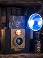 Die „Geister Fotoapparat 24 cm mit Licht animiert“ projiziert ein gruseliges Totenkopfbild und schafft so die perfekte Kulisse für eine unheimliche Halloween-Dekoration. Umgeben Sie ihn mit antiken Büchern, deren Buchrücken mit Totenkopfmotiven verziert sind, einem blau leuchtenden Horn und einer Glasflasche mit der Aufschrift „Witch’s Brew“ für die ultimative gruselige Deko – perfekt für jeden Fan von stimmungsvoller Halloween-Dekoration.