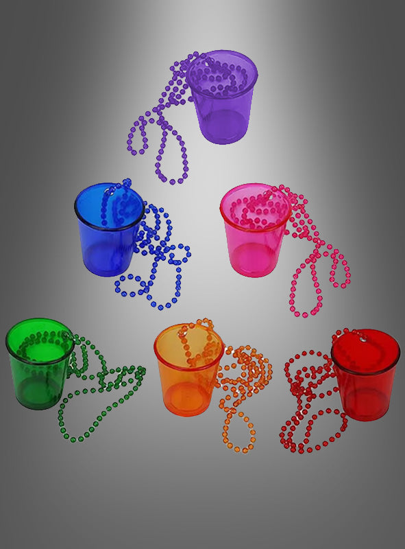 Fünf durchsichtige Schnapsgläser aus Kunststoff mit Kette – jeweils in leuchtendem Blau, Grün, Violett, Orange oder Rot – sind mit farblich passenden Perlenketten kombiniert und auf einem grauen Hintergrund mit Farbverlauf angeordnet.