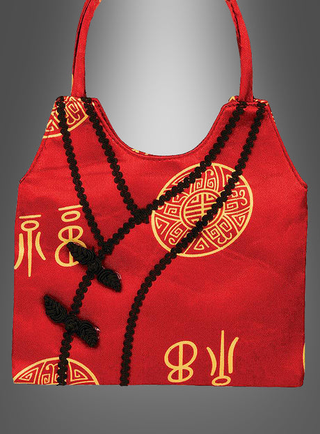 Asia-Handtasche „Geisha Japanerin“ mit goldenen chinesischen Schriftzeichen und schwarzer Zierborte auf der Vorderseite, dargestellt vor einem grauen Hintergrund mit Farbverlauf – ein stilvolles Accessoire, das sich ideal zur Ergänzung Ihrer Asia-Handtaschen-Kollektion eignet oder jedem chinesischen Kostüm eine authentische Note verleiht.