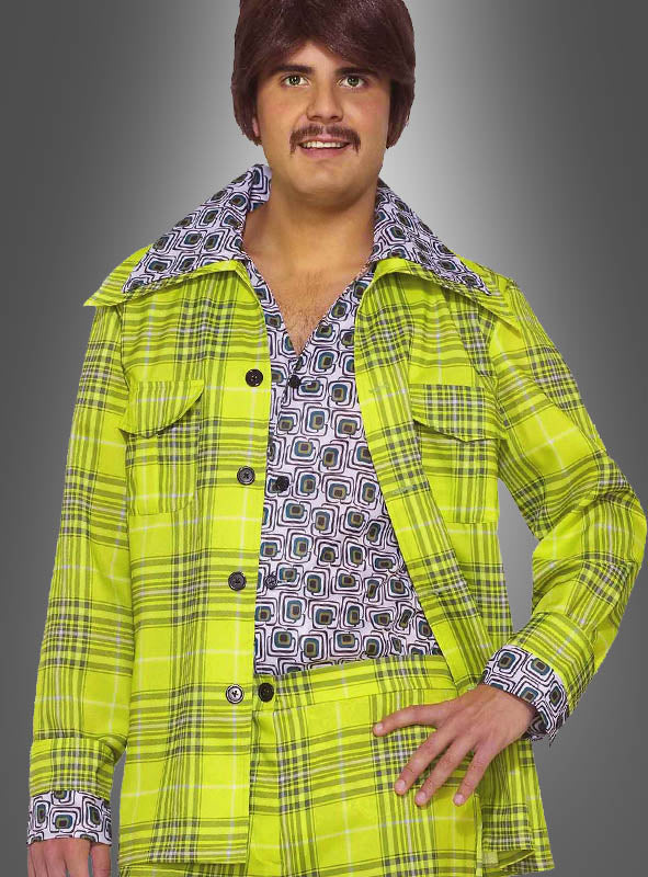 Ein Mann trägt das 70er-Jahre-Kostüm – einen limettengrünen Karierten Anzug mit einem gemusterten Hemd mit breitem Kragen und einer dazu passenden Hose –, das das ikonische Schlager-Disco-Outfit der 1970er Jahre perfekt verkörpert, während er vor einem grauen Hintergrund posiert.