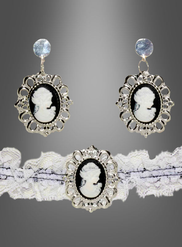 Die silbernen Kameo-Ohrringe und das dazu passende Spitzenhalsband aus dem „Steampunk Schmuck Cameo“-Set zeigen schwarz-weiße Porträts in kunstvollen Rahmen, die die Eleganz des Steampunk-Stils perfekt einfangen – ein ideales Statement-Stück für Gothic-Bräute. Vor einem Hintergrund mit Farbverlauf präsentiert, verbindet dieses Ensemble Vintage-Charme mit modernem Flair.