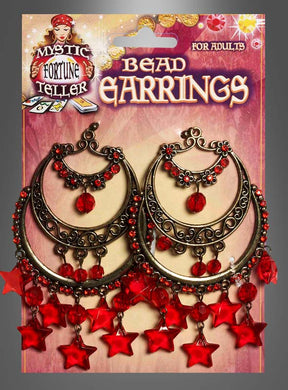 Ein Paar große, kunstvoll verzierte, bronzefarbene „Orientalische Ohrringe“ mit roten Perlen und sternförmigen Anhängern versprühen den Charme von Bauchtänzerin-Schmuck. Sie sind mit einem „Mystic Fortune Teller“-Etikett und der Aufschrift „Bead Earrings“ verpackt.