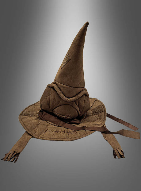 Ein brauner sprechender Hut aus der Zauberschule mit hoher, spitzer Form, breiter Krempe, sichtbaren Nähten und zwei herabhängenden Stoffstreifen – in Anlehnung an den legendären sprechenden Hut aus Harry Potter – vor einem grauen Farbverlauf. Das ideale Accessoire für jedes Zaubererkostüm.