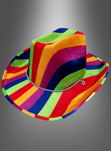 Die „Cowboyhut Regenbogen“ besticht durch ein auffälliges, mehrfarbiges Regenbogenmuster und ein schwarz-weißes Flechtband, das sich vor einem grauen Hintergrund mit Farbverlauf abhebt.